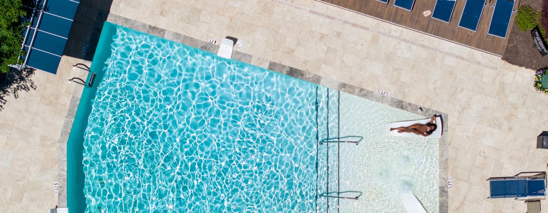 aerial view of a pool with a woman sitting in the water