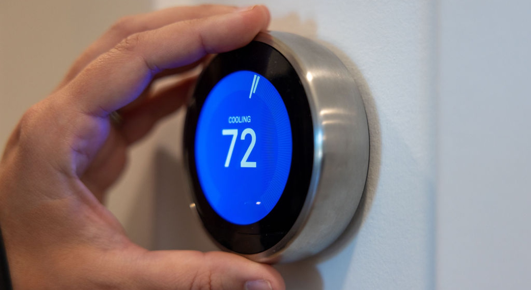 a hand holding a thermostat