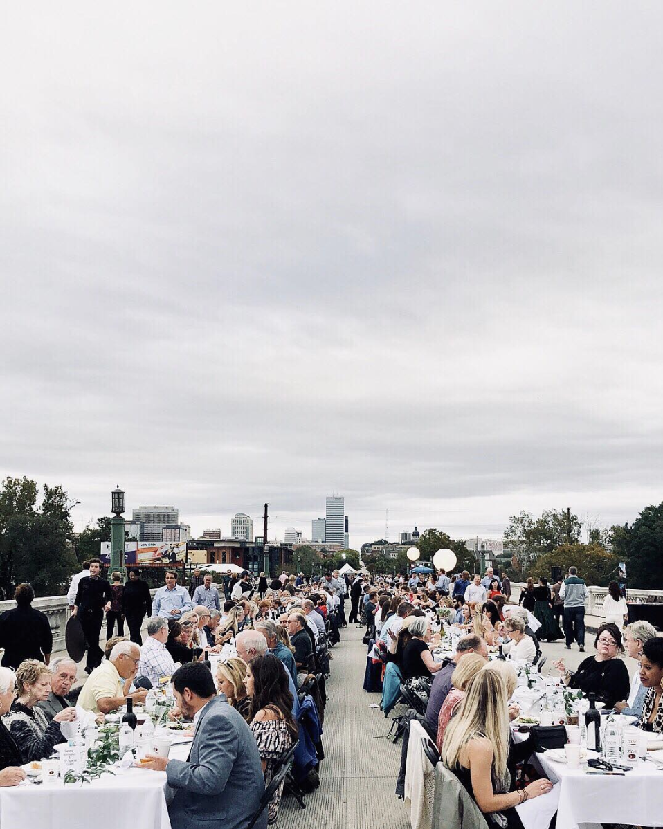 People sitting on Gervais Street Bridge having dinner to celebrating it’s opening